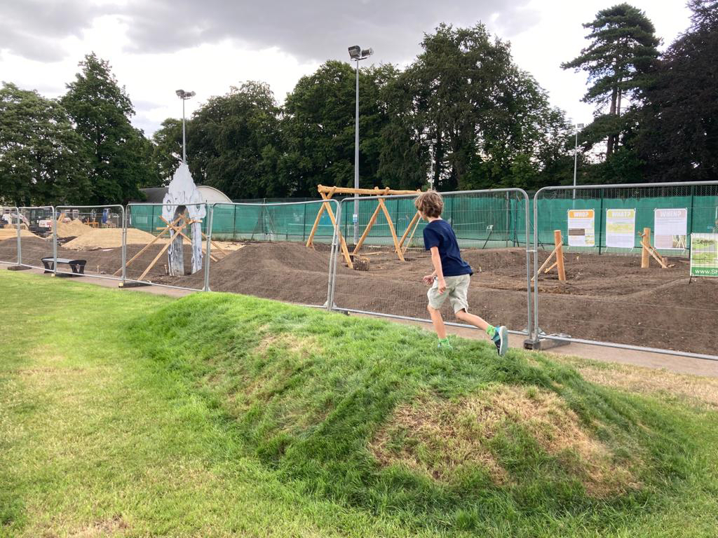 Child running over a grass mound